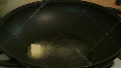 Male hands omit the butter in the pan. Russian cuisine.