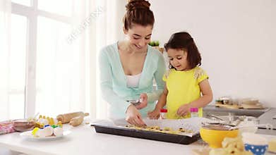 Happy mother and daughter making cookies at home