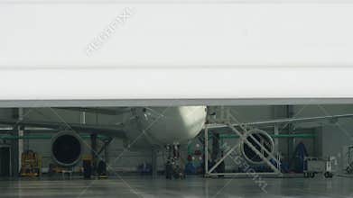Roller shutter door and plane in hangar background. Business jet airplane is in hangar. Private corporate jet parked in