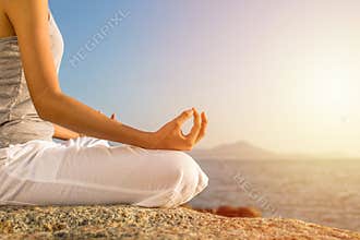 Young woman meditation yoga pose on tropical beach with sunlight