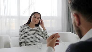 Portrait of miserable woman Seated at table at psychotherapist, dialog of Office worker and boss,