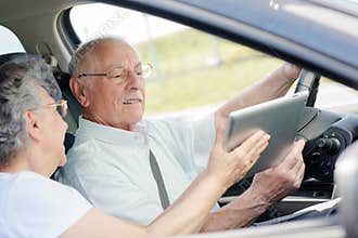 Old couple driving new car