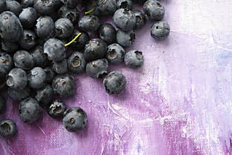 Fresh healthy berries of blueberries on lilac abstract canvas