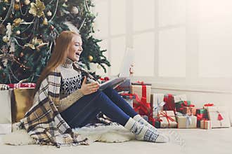 Surprised woman online on laptop at christmas interior