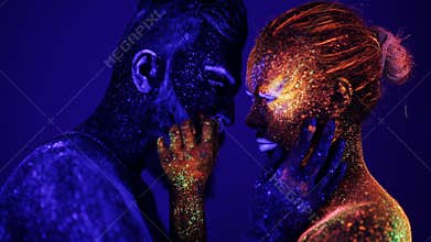 A man and a woman in the ultraviolet light caress each other. Fire and ice, two hypostases.