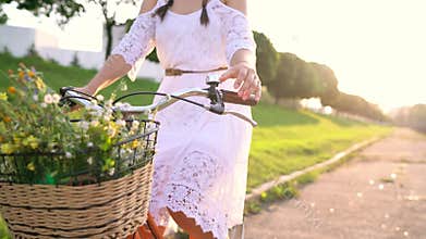 Young beautiful woman riding a bicycle at sunset. Slow motion