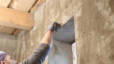 An impressed builder standing and measuring the wall on a construction site