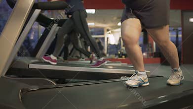 Unhealthy fat woman barely walking on treadmill, working hard to lose weight