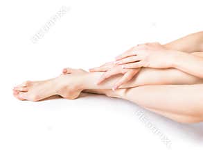 Closeup shot of a woman applying moisturizer to her leg and feet. Beauty feet and hands isolated on white background