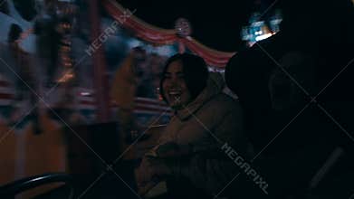 In the park amusement is a young beautiful woman on the merry-go-round.