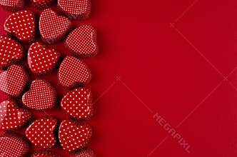 Decorative border of red hearts on passion red paper background. Valentine day backdrop.