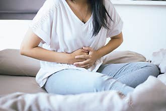 Woman having painful stomachache standing in the bedroom,Female suffering from abdominal pain