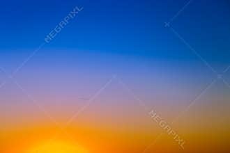 Background with gradient sunset sky in tones of yellow, orange and blue