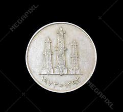Reverse of vintage coin made by United Arab Emirates that shows Oil derricks