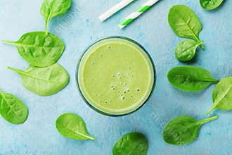 Green spinach smoothie on blue table top view. Detox and diet food for breakfast.