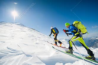 Cross country skiing team couple of men towards the summit of th