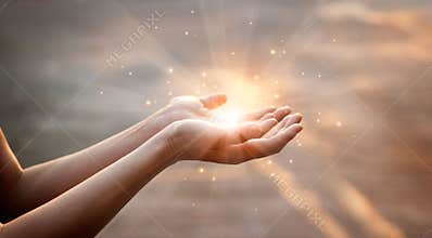 Woman hands praying for on sunset background