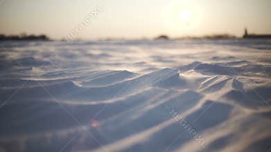 Arctic Storm. Close-up shot of snow storm at sunset. Wind picks snowflakes and carries them across the field