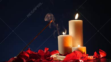 Incense sticks and candles are burning and smoke on dark background,Smoke from incense and candle light