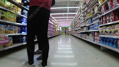 Shelves with goods in supermarket. Grocery shopping from view of a shopping cart. Thailand.