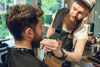 Handsome young man sitting on the chair of a barbershop
