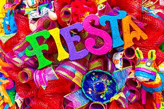 The word `fiesta` written in colorful foam letters on multicolored mash decorated with glitter and small sombrero