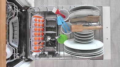 Filling dirty dishes in the dishwasher.Timelapse, 4K