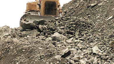 Earth Mover Pushing Loose Rocks Toward The Camera