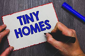 Writing note showing Tiny Homes. Business photo showcasing houses contain one room only or two and small entrance Cheap Man holdin