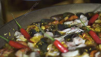 Chef cook cooking spanish paella with red hot peppers and fresh seafood in pan close up. Preparation traditional spain
