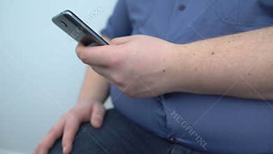 Overweight man typing smartphone message, fitness training program online, diet