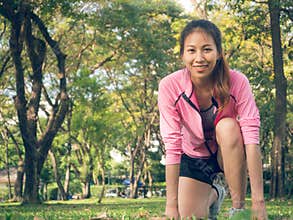 Asian young woman on mark to set ready for jogging exercise to build up her body on glass in warm light morning.