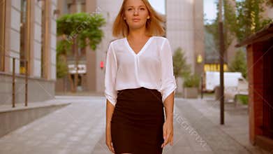 Blonde female walks in business area of town