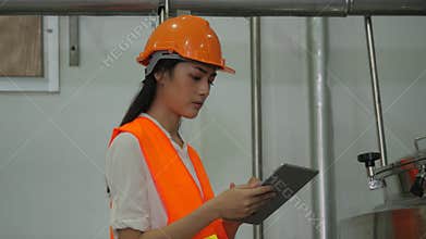 Woman engineer looking at computer tablet and checking data on the tablet