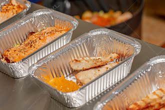 Multiple meals ready to eat packaged in aluminum disposable food containers, take away healthy food restaurant concept. Healthy co