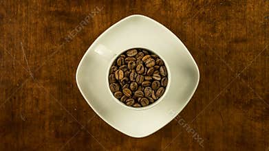 Coffee cup filled with beans stop motion animation turning clockwise topview