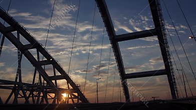 Drive through the Brige under construction with dramatic Clouds and the setting Sun. Sunset