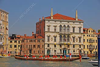 A group of elderly boat rowers with a very long boat taking a rest during the Vogalonga Regatta festival in Venice, Italy