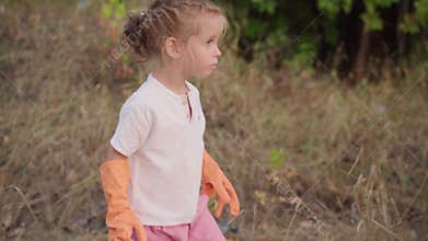 Little girl helps mother collects plastic garbage on nature