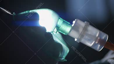 A female patient in medical mask is breathing oxygen support in a hospital next to heart rate machine. Unhealthy woman