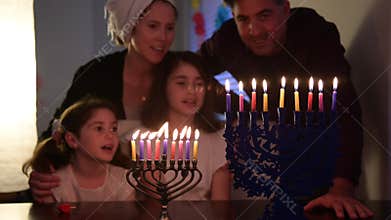 Family kindling candles on the eight day of Hanukkah Jewish holiday festival