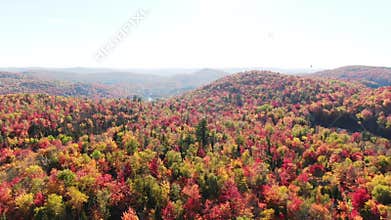 Aerial view above the colorful mountains of Autumn moving down slowly and showing the lakes, rivers and mist on the mountains