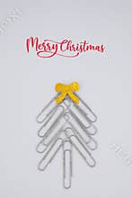 Concept merry xmas in the office. Xmas tree made of paper clips on the white background. paper clip Christmas tree. Christmas