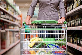 Female Shopper With Trolley at Supermarket