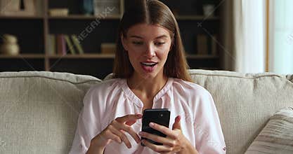 Excited millennial woman scroll betting results on phone winning prize