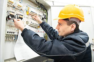 Electrician with drawing at power line box