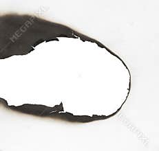 Burnt hole isolated on white paper. burns borders paper close up