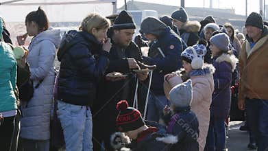 Lviv, Ukraine - March 15, 2022: People eating at the railway station while waiting for evacuation for refugees, escorted