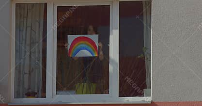 Boy holding picture rainbow in window home. Painted sign, attracting attention