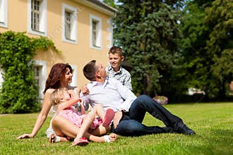 Family sitting in front of their home
